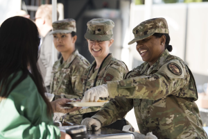 Three female soldiers helping the Community